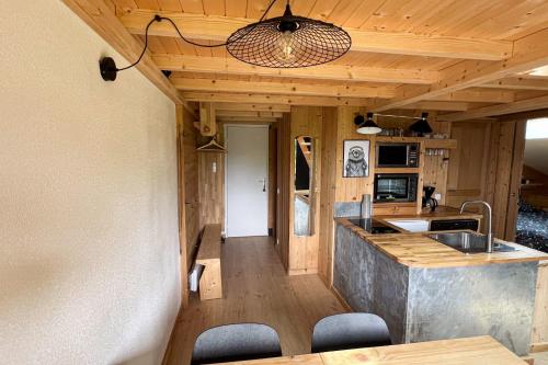 une cuisine avec un évier et un comptoir avec des chaises dans l'établissement T2 with pool in Saint-Gervais-les-Bains, à Saint-Gervais-les-Bains