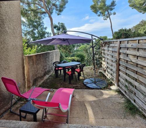 un patio avec une table, des chaises et un parasol dans l'établissement Quiet studio with terrace near the sea, à La Seyne-sur-Mer