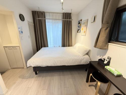 a bedroom with a bed and a desk and a window at NDZ103 3 min walk to station, 2 lines, Yamanote Line, high-speed Wi-Fi in Tokyo