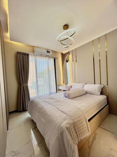 a bedroom with a large bed and a window at Arrayyan Executive Village Kota Batu in Batu