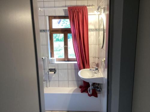 Un baño con lavabo, bañera y ventana. en Ferienhaus Rhönmantisch - Landleben und Stille, en Brembach