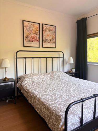 a bedroom with a bed and two pictures on the wall at Vila Felicia in Cabeceiras de Basto