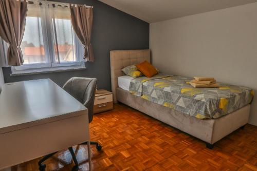 a bedroom with a bed and a desk and a window at Sonnengarten floor 1 in Marčana