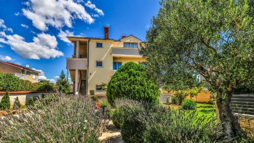 a house with trees and bushes in front of it at Sonnengarten floor 1 in Marčana