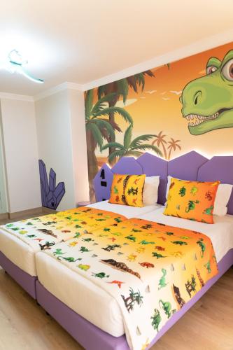 a bedroom with a dinosaur mural on the wall at Ukino Palmeiras Village - 24h All Inclusive in Armação de Pêra