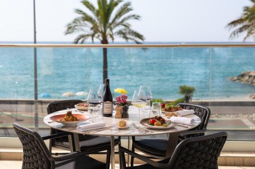 a table with plates of food and a view of the ocean at Hotel Royalmar - Nouveau propriétaire in Cagnes-sur-Mer