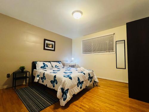 a bedroom with a bed with a white and blue comforter at Cozy Stay, Self Check-In with Parking available upon request in Toronto
