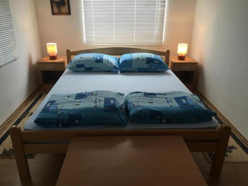 a bed in a room with two blue pillows at Apartman Blagaj in Blagaj