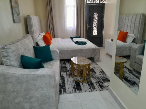 una sala de estar con un sofá y una cama en Naiposha Studios, en Munyu