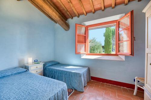 a bedroom with two beds and a window at Poggio D'Arno in Asciano