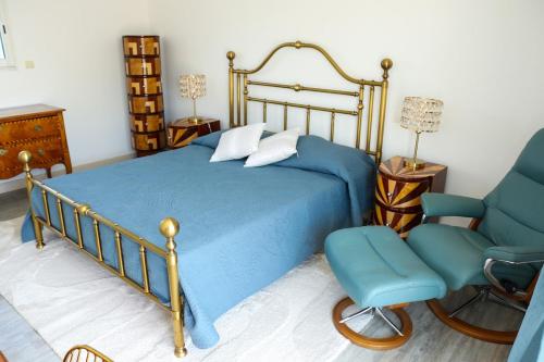a bedroom with a blue bed and a chair at Villa Casa Bianca Beachfront Villeroy in Sète