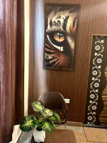 a picture of a tigers eye on a wall with a chair at ASHOKA PALACE in Sawāi Mādhopur