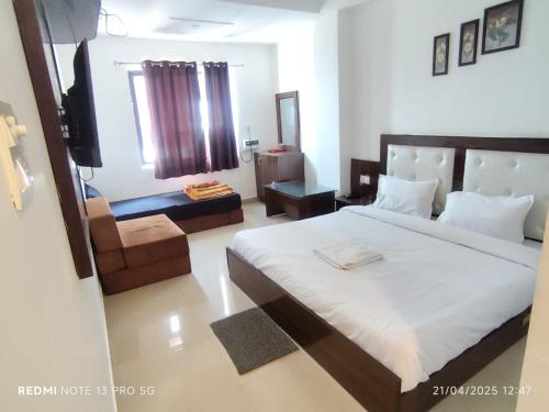 a bedroom with a bed and a television in it at Hotel Navgrah Palace in Haridwār