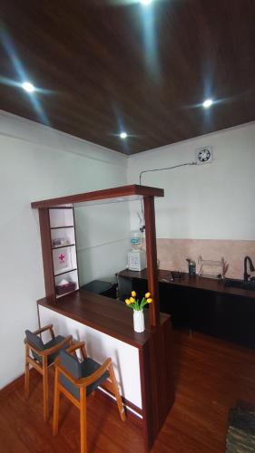 a kitchen with two chairs and a table with a counter at Skypiea Dieng in Dieng