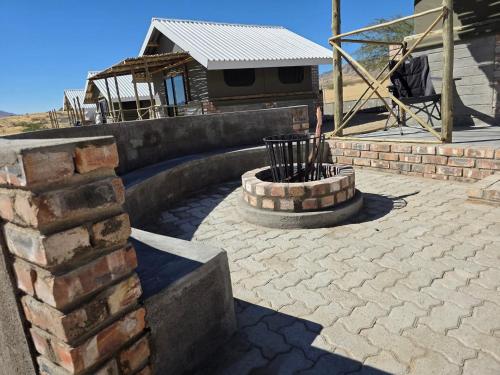 a patio with a brick wall and a fountain at Carlo's Mountain Lodge in Usakos