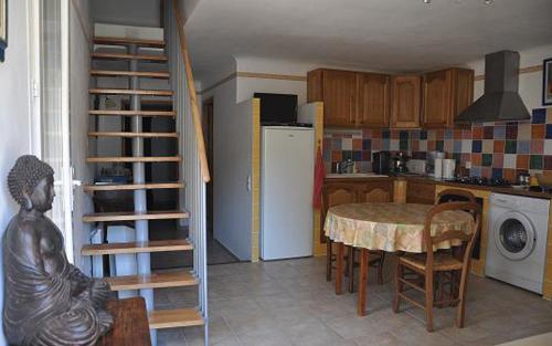 Il comprend une cuisine équipée d'une table et d'un réfrigérateur. dans l'établissement Gite 