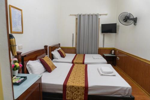 a hotel room with two beds and a television at Pho Nang Motel in Hanoi