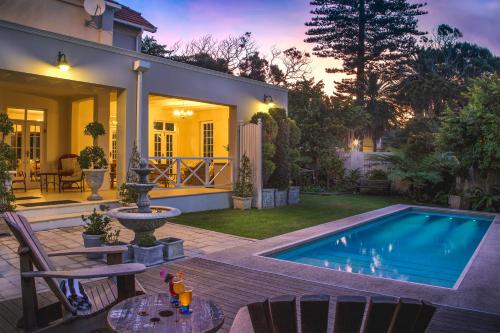 a backyard with a swimming pool and a house at Bright on 5th Guest house in Port Elizabeth