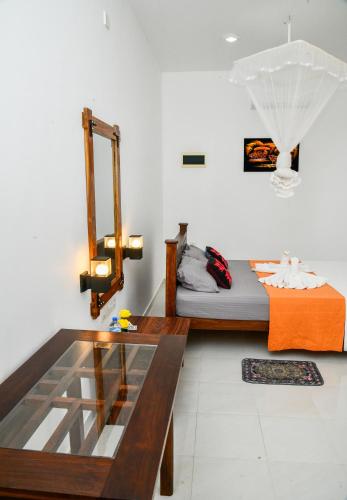 a living room with a table and a bed at Eco Friendly Lodge in Udawalawe