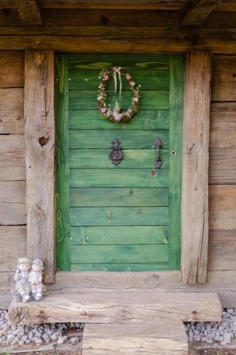 a green door of a house with a wreath on it at Kozline Kordun in Veljun