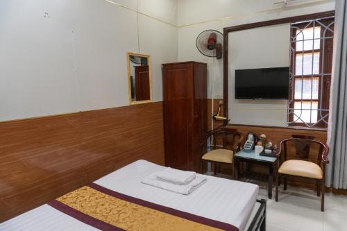 a room with a bed and a table and a television at Pho Nang Motel in Hanoi