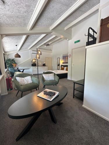 a living room with a table and chairs and a bed at De Strandgaper in Zevenhuizen