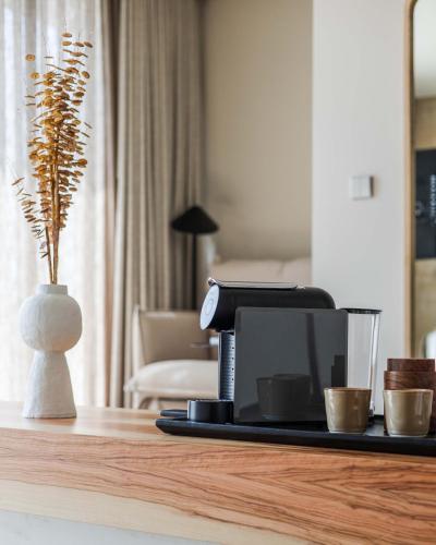 a table with a coffee maker and a vase with a plant at Upon Vila - Alcochete Hotel in Alcochete