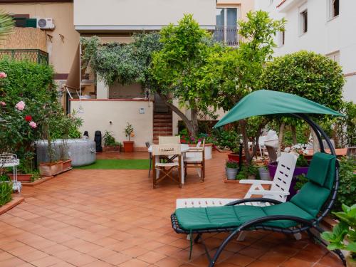 a patio with chairs and an umbrella and a table at MONDELLO COTTAGE in Mondello