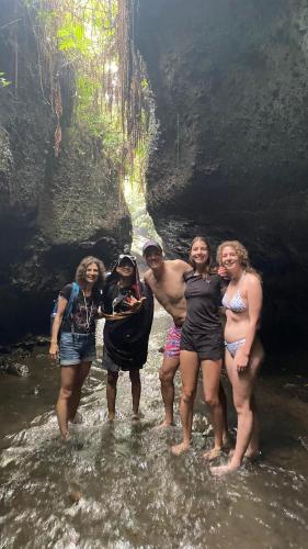 a group of people standing in the water in a cave at Lombok Grace Bungalows in Tetebatu