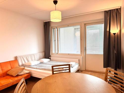 a small room with a bed and a table at Transit Apartments HEL Airport in Vantaa