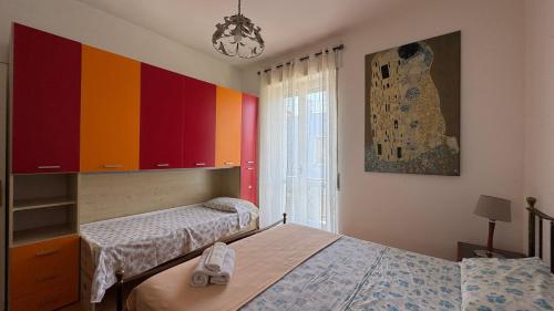 two beds in a room with colorful cabinets at casAmare in Pescara