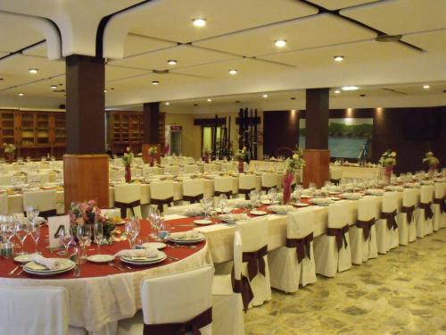 un gran salón de banquetes con mesas blancas y sillas blancas en Hostal Salones Victoria, en Santa Marina del Rey