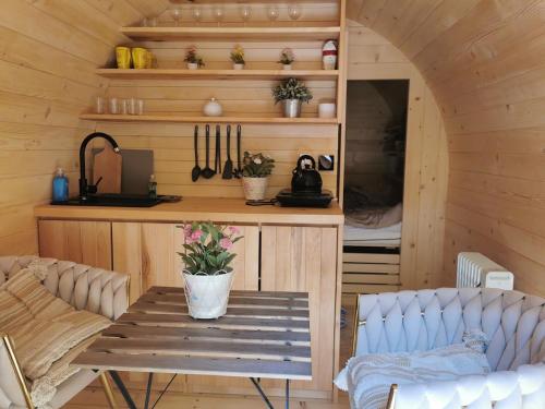 a room with a table and a kitchen in a cabin at Hope Mountain Escape Poland, Charming Barrel House in Szczawa