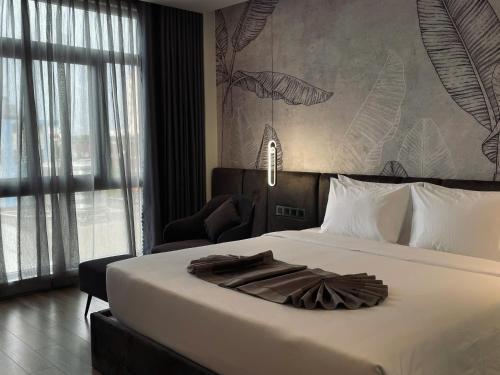 a bedroom with a large white bed with a large window at LION 17 Hotel in Can Tho
