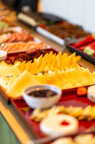 a tray of cheese and other food on a table at DeSilva Inn Opole in Opole