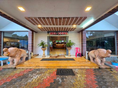 a lobby with two statues of elephants in front of a building at Relax Adventure Resort in Igatpuri