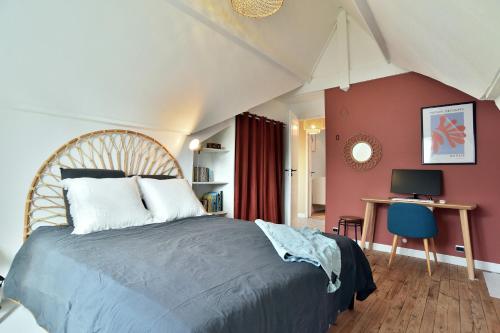a bedroom with a large bed and a desk at Kerchoupi - Proche centre-ville Saint Malo in Saint Malo