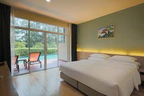 a bedroom with a large bed and a large window at The Kaset, Hua Hin in Hua Hin