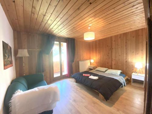 a bedroom with a bed and a chair in it at CASA-Lodge Lili pour 2 personnes in Molines-en-Queyras