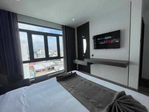 a bedroom with a bed and a large window at LION 17 Hotel in Can Tho