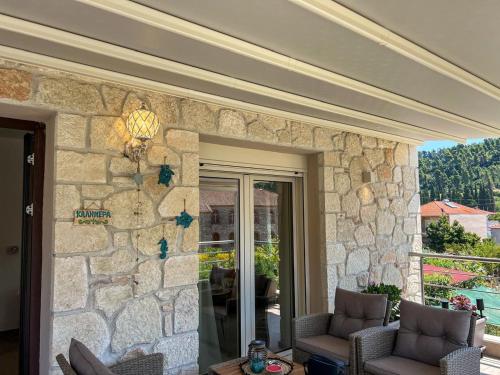 a stone wall with two chairs on a patio at Magda's Cosy House Fourka in Fourka
