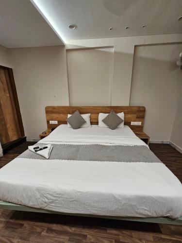 a bedroom with a large bed with white sheets at Hotel Petal Inn in Nagpur