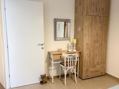 a room with a desk with a mirror and a chair at Magda's Cosy House Fourka in Fourka