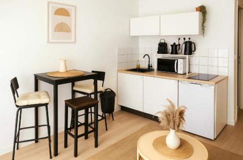 une petite cuisine avec un comptoir et un micro-ondes dans l'établissement Charmant studio au cœur de CAEN, à Caen