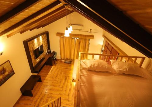 a bedroom with a bed and a wooden floor at Lotus Hotel & Resort in Ambernath