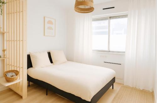 une chambre blanche avec un lit et une fenêtre dans l'établissement Charmant studio au cœur de CAEN, à Caen