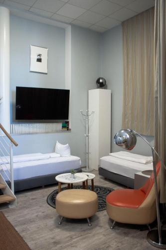 a room with a bed and a couch and a table at Ferienwohnungen Edison 52 by Lorenc in Berlin