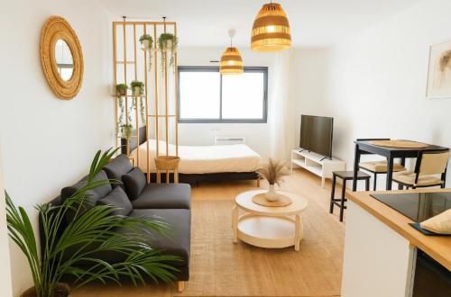 un salon avec un canapé et une table dans l'établissement Charmant studio au cœur de CAEN, à Caen
