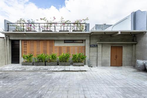 a house with a balcony on top of it at SNUG Kuta in Kuta