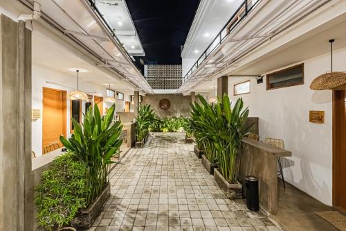 a hallway with potted plants in a building at SNUG Kuta in Kuta